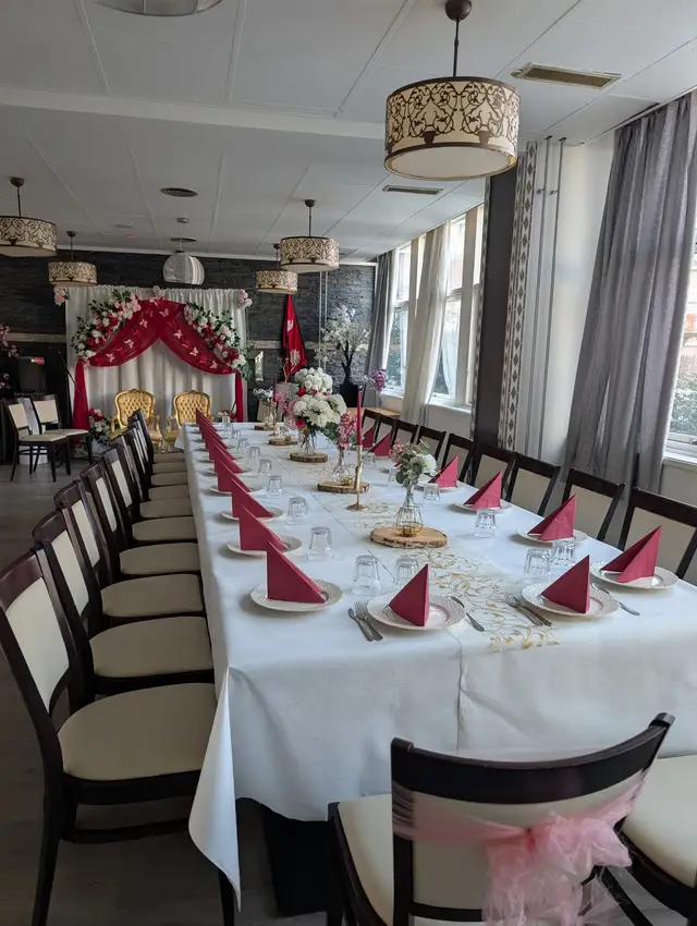 A table set for a celebration with red napkins, blossom branches and candles