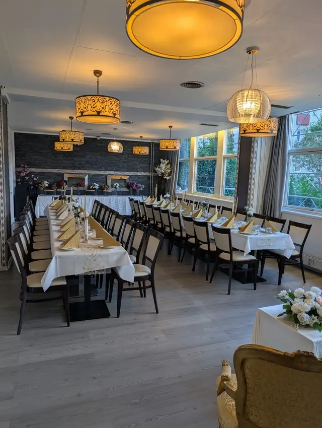 The hall arranged with separate tables in cream and gold, wooden floor and tall windows